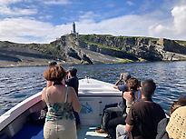 Pasajeros frente al faro de Cabo Mayor